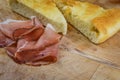 Sliced italian smoked speck ham with focaccia bread on a wooden cutting board Royalty Free Stock Photo