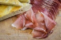 Sliced italian smoked speck ham with focaccia bread on a wooden cutting board Royalty Free Stock Photo