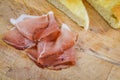 Sliced italian smoked speck ham with focaccia bread on a wooden cutting board Royalty Free Stock Photo