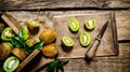 Sliced kiwi on the old board with knife and box. Royalty Free Stock Photo