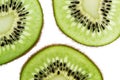 Sliced kiwifruit rings on white background top view macro