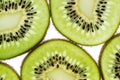 Sliced kiwifruit rings on white background top view macro