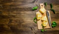 Sliced lemon on the board with leaves. Royalty Free Stock Photo