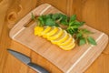 Sliced lemon and mint leaves on a cutting board with a knife Royalty Free Stock Photo