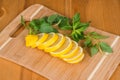 Sliced lemon with mint leaves on a cutting board Royalty Free Stock Photo