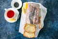 Sliced lemon poppy seed bundt cake covered with a glaze on a wire rack. Blue stone background. Top view. Royalty Free Stock Photo