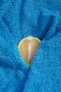 Sliced lemon with turquoise towel. Partially covered.