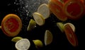Sliced lemons and oranges falling into the water
