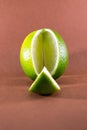 Sliced lime fruits isolated on brown background Royalty Free Stock Photo