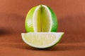 Sliced lime fruits isolated on brown background Royalty Free Stock Photo