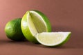 Sliced lime fruits isolated on brown background Royalty Free Stock Photo