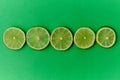 Sliced limes on a green background Royalty Free Stock Photo