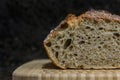 Sliced loaf of artisanal whole wheat and dark rye rustic sourdough bread on a cutting board, baked at home, photo series