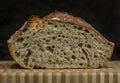 Sliced loaf of artisanal whole wheat and dark rye rustic sourdough bread on a cutting board, baked at home, photo series