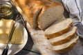 Sliced loaf of bread on a cutting board with butter and herbs. Top view Royalty Free Stock Photo