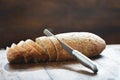 Sliced loaf fresh bread knife wooden table close up Royalty Free Stock Photo