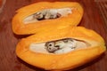 Sliced mango with bone on wooden kitchen cutting board