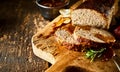 Sliced Meatloaf on Wood Board with Herbs and Gravy