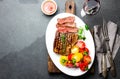 Sliced medium rare grilled beef steak served on white plate with tomato salad and potatoes balls. Barbecue, bbq meat Royalty Free Stock Photo