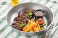 Sliced medium rare grilled Steak Ribeye with french fries and glass of beer on the table Royalty Free Stock Photo