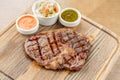 Sliced medium rare grilled Steak Ribeye with Pickled cabbage and two sauces. Serving on a wooden Board. Barbecue Royalty Free Stock Photo