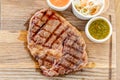 Sliced medium rare grilled Steak Ribeye with Pickled cabbage and two sauces. Serving on a wooden Board. Barbecue Royalty Free Stock Photo