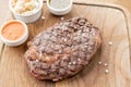 Sliced medium rare grilled Steak Ribeye with Pickled cabbage and two sauces. Serving on a wooden Board. Barbecue Royalty Free Stock Photo