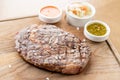 Sliced medium rare grilled Steak Ribeye with Pickled cabbage and two sauces. Serving on a wooden Board. Barbecue Royalty Free Stock Photo