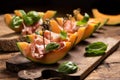 Sliced melon with ham and basil leaves, served on a wood chopping board Royalty Free Stock Photo