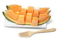 Sliced melon in pieces on a white plate with wooden fork. Royalty Free Stock Photo