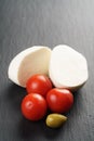 Sliced mozarella ball with tomato and olives on slate background Royalty Free Stock Photo