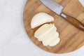 Sliced Mozarella cheese on the round wooden board Royalty Free Stock Photo