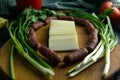 Sliced mozzarella on a wooden board, around the ham, green onions, tomato, souce, olives, lemon, spice, dill Royalty Free Stock Photo