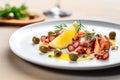 sliced octopus with capers and a lemon twist garnish