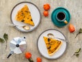 Sliced open pie with pumpkin and prunes on a ceramic plate on a gray concrete background. Pumpkin recipes. Thanksgiving desserts