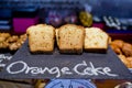 Sliced orange breads on black board and Orange cake hand-sketched typographic element on chalkboard background.Bakery label.