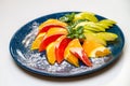 Sliced orange, grapefruit, apple and mint leaf on a blue plate Royalty Free Stock Photo