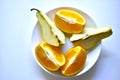 Sliced orange and green pear slices on a white plate Royalty Free Stock Photo
