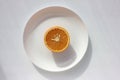 Sliced orange on a plate on white background. Top view, copy space. Royalty Free Stock Photo