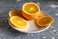 Sliced orange on a white plate on dark wooden table Royalty Free Stock Photo
