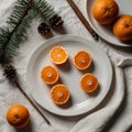 Sliced oranges are arranged on a decorative white plate positioned on a textured white tablecloth Royalty Free Stock Photo