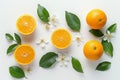 Sliced oranges with blossoms and green leaves on white background, fresh and vibrant display