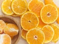 Sliced oranges on wooden chopping board arranged around