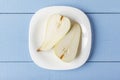 Sliced pears on wooden table. Organic fruits on white plate for dietary brakfast or dinner. Rustic lifestyle concept. Top view. Co Royalty Free Stock Photo