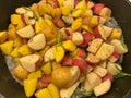 Sliced, peeled raw potatoes in a pan with some herbs and spices Royalty Free Stock Photo