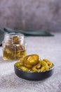 Sliced pickled jalapeno peppers in bowl and glass jar on table vertical view Royalty Free Stock Photo