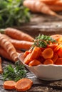 Sliced pieces of carrot in a bowl and a fresh bunch of carrots in the background Royalty Free Stock Photo