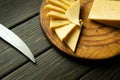 Sliced pieces of cheese with a knife on a cutting board. Fast food or street food concept on vintage table. Cheese tasting Royalty Free Stock Photo