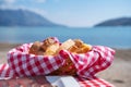Sliced pieces of freshly baked hot aromatic bread lie in basket on checkered cloth napkin on table in cafe on terrace on the sea Royalty Free Stock Photo