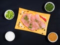 Sliced pieces of meat turkey game filet on a wooden cutting board, fenugreek, salt, fennel, allspice, green onion, red chili Royalty Free Stock Photo